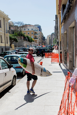 Matt Lewis picking up a board inCagliari, Sardinia